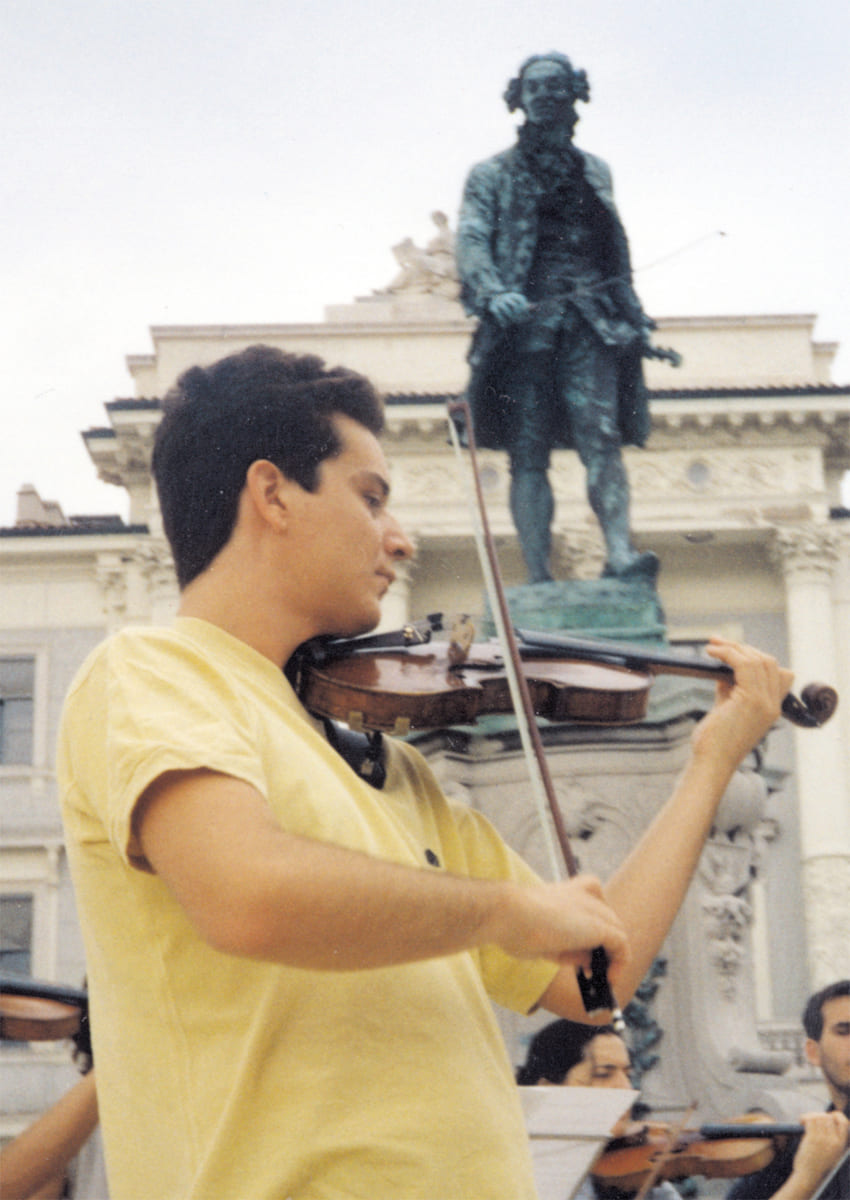 José Manuel Gil de Gálvez, autor del artículo, tocando ante la estatua de Giuseppe Tartini en la Plaza Tartini de Pirano (Eslovenia, 2000)