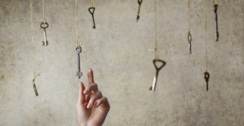 hand stretching for one of the many old vintage keys hanging on threads